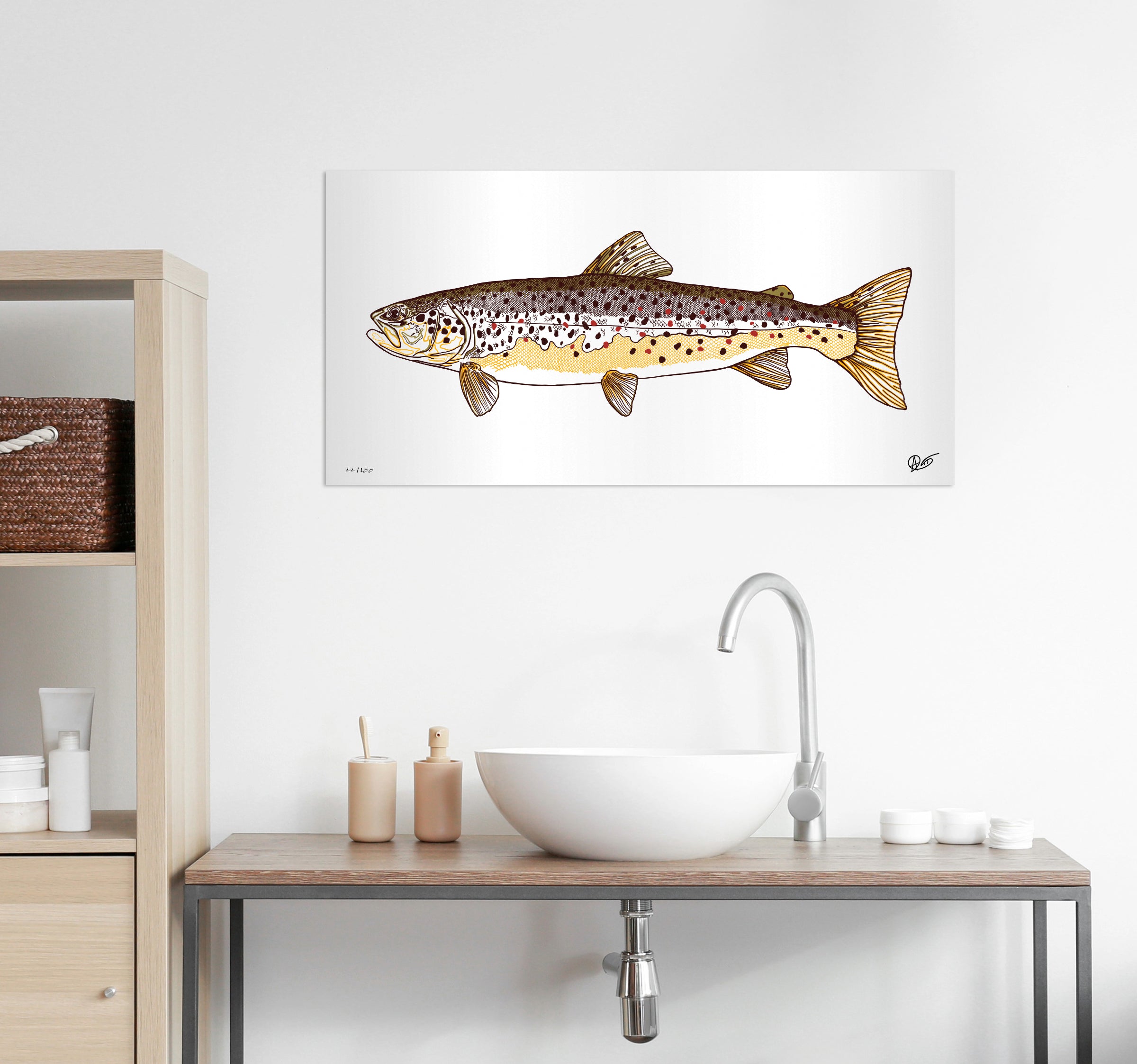 Brwon trout metal print on a wall above a bathroom sink with wooden cabinets.