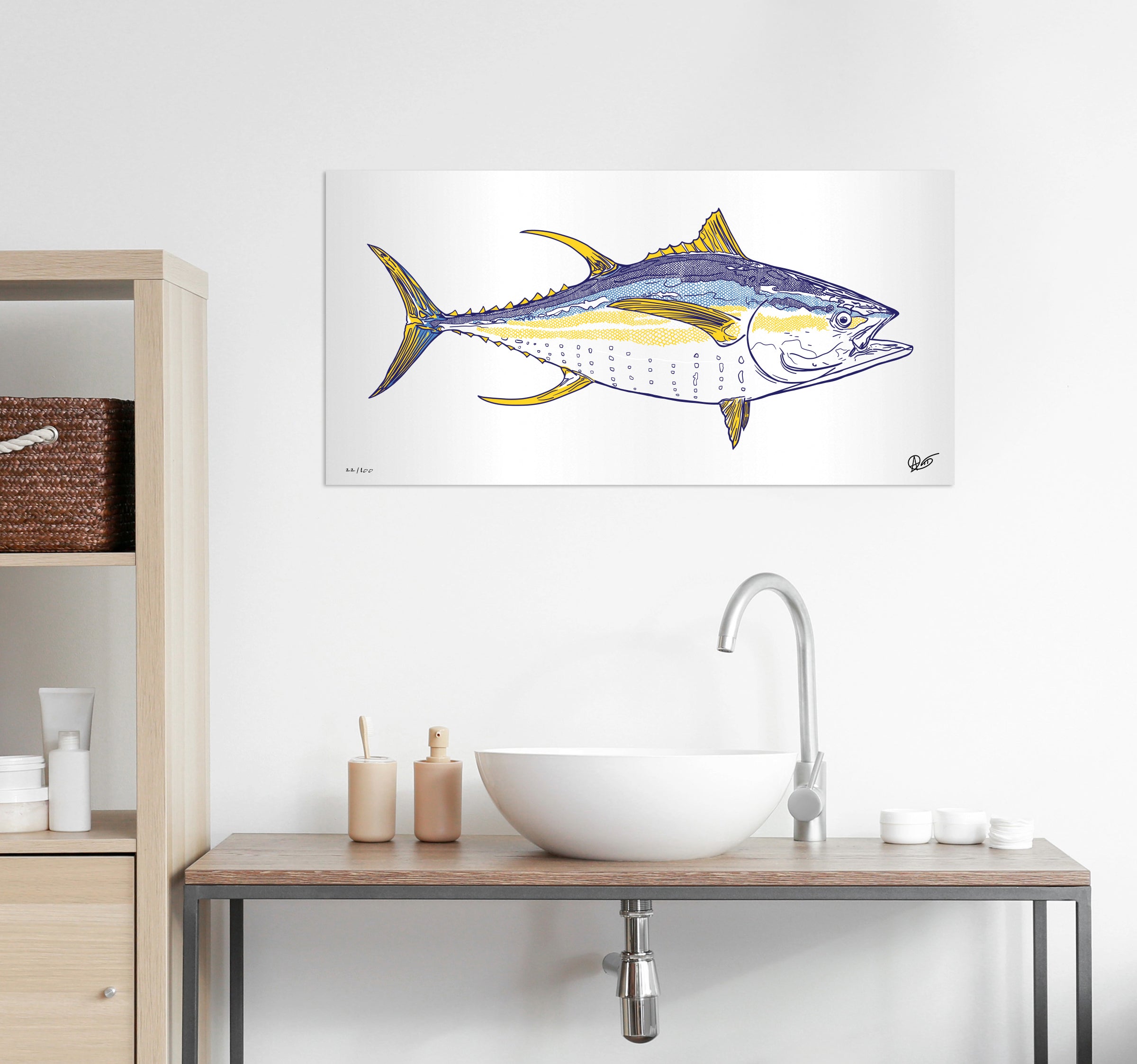 Framed artwork of a yellowtail metal print hanging above a bathroom sink with shelves.