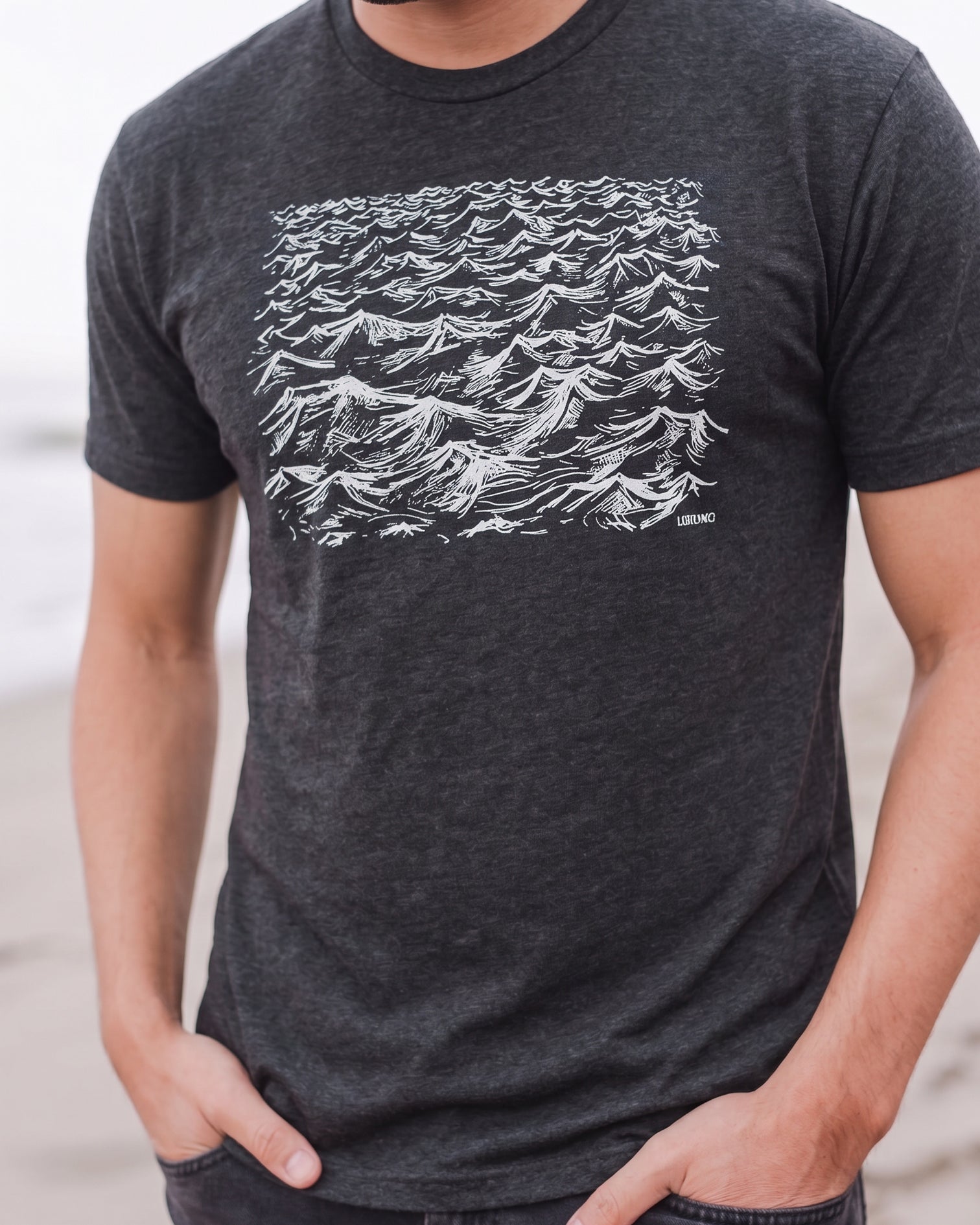 Person wearing a dark gray t-shirt with white wave design