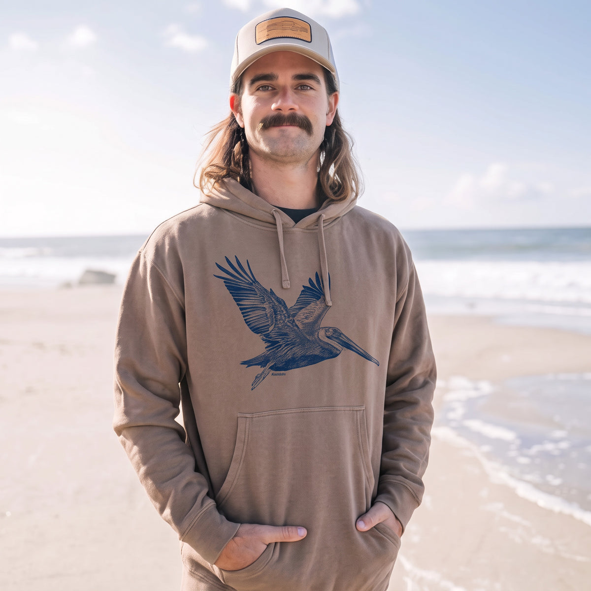 man wearing a clay pelican t-shirt with blue pelican design