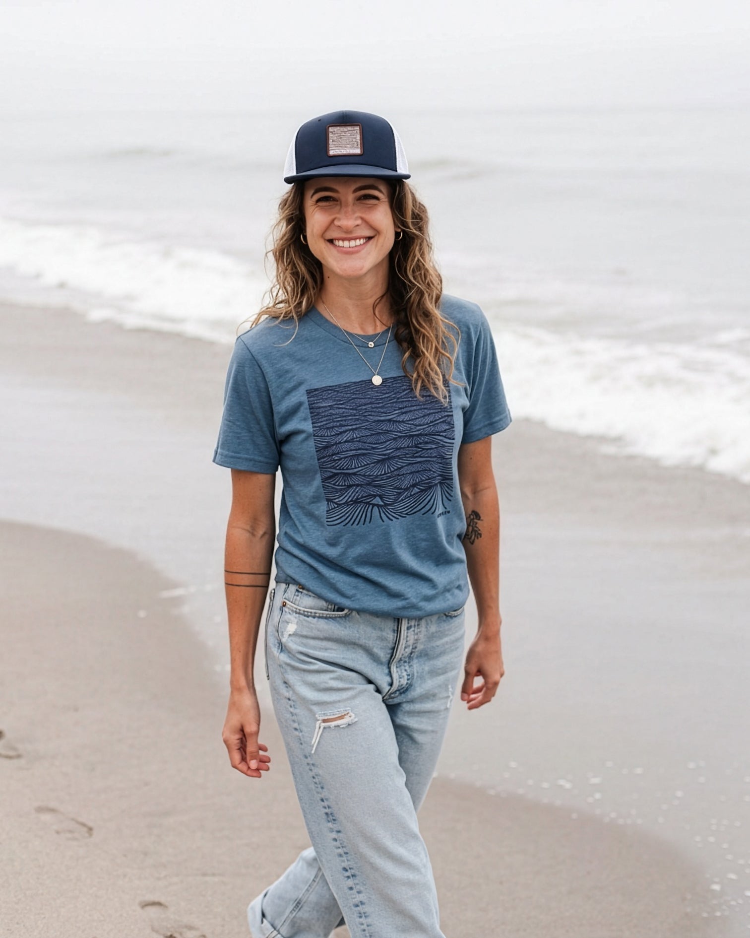Woman wearing a blue t-shirt and cap on a beach